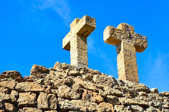 The crosses of the Turó de les Tres Creus, the stone calvary at the top of Park Güell, against a blue sky