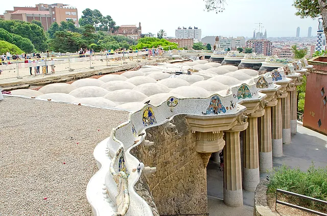 The Nature Square of Park Güell in 2018 with the surface removed, showing the rows of white domes that form the ceiling of the Hypostyle Hall below, with the serpentine bench along the edge